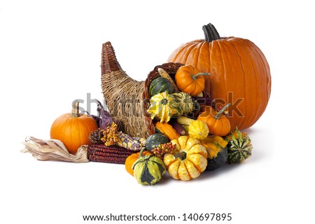Shot of a pumpkin beside a wicker cornucopia on white.