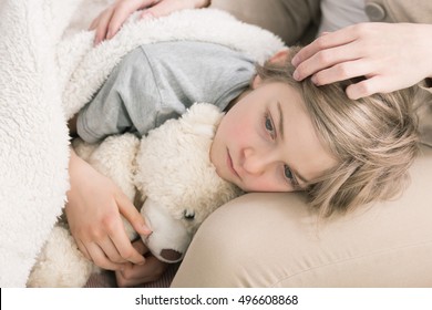 Shot Of A Sad Sick Boy Keeping His Head On His Mother's Lap