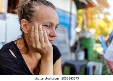 Shot Of Sad Woman Sitting Outdoor. Woman Outdoors In Nature Holding Her Head Expressing Pain, Exhaustion, Sadness Or Depression. Concerned Serious Mature Woman. Photo Of A Beautiful Thoughtful Female.