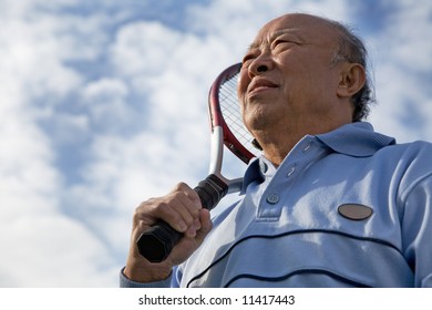 A Shot Of A Senior Asian Man Holding A Tennis Racquet