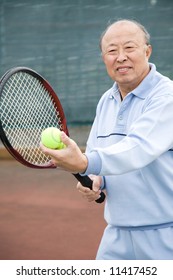 A Shot Of A Senior Asian Man Playing Tennis