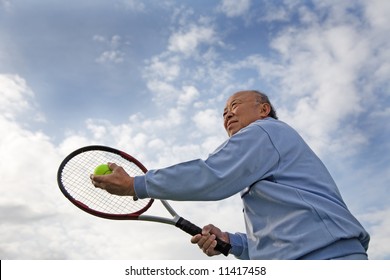 A Shot Of A Senior Asian Man Playing Tennis