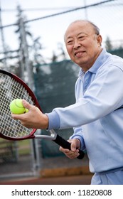 A Shot Of An Senior Asian Man Playing Tennis