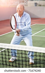 A Shot Of A Senior Asian Man Playing Tennis