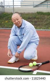 A Shot Of A Senior Asian Tennis Player Tying Up His Shoes