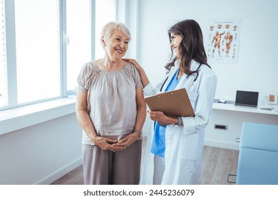 Shot of a senior woman having a consultation with her doctor. Senior woman having a doctors appointment. Doctor in blue uniform and protective face mask giving advice to Senior female patient  - Powered by Shutterstock