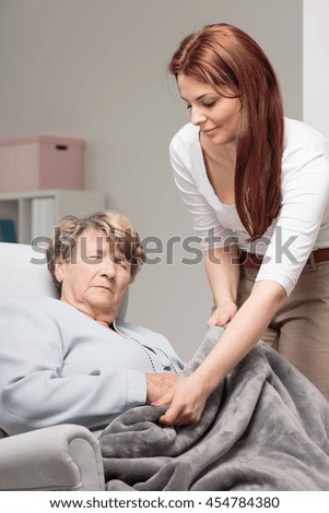 Caregiver auscultating senior woman