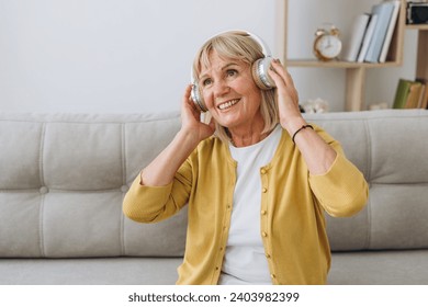 Shot of a senior woman wearing headphones while listening to music at home. Some tunes will stay my favourite forever.  - Powered by Shutterstock