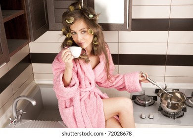 Shot Of Sexy Housewife In Pink Dressing Gown Cooking Dish In Kitchen Room