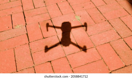 A Shot Of The Shadow Of A Drone On A Red Brick Patio On A Sunny Day In New York, USA