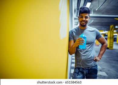 Shot of smiling african american athlete man enjoying drinking water after a workout. - Powered by Shutterstock