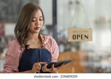 Shot Of Smiling Asian Young Sme Small Business Owner Wearing Apron And Standing White Ipad And Open Sign Coffee Shop Door, Asian Business Woman Barista Cafe Owner SME Entrepreneur Seller Concept