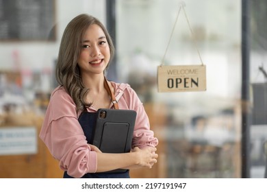 Shot Of Smiling Asian Young Sme Small Business Owner Wearing Apron And Standing White Ipad And Open Sign Coffee Shop Door, Asian Business Woman Barista Cafe Owner SME Entrepreneur Seller Concept