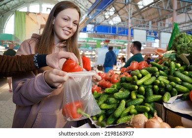 Shot Of Smiling Female Customer Buying Fresh Vegetables In Market.