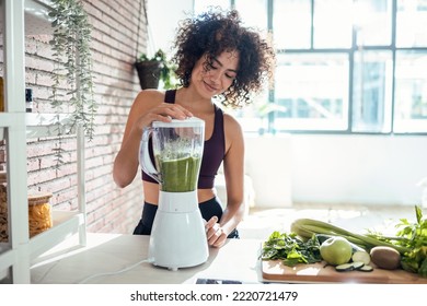 Shot of sporty young woman making a vegetable green smoothie in the kitchen at home. - Powered by Shutterstock