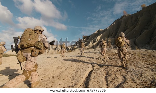 Shot of a Squad of\
Soldiers Running Forward and Atacking Enemy During Military\
Operation in the Desert.