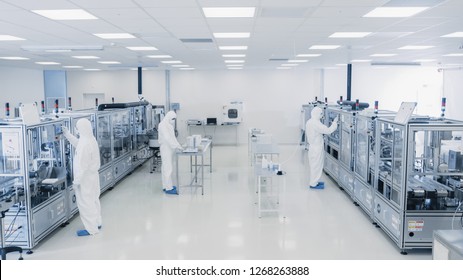 Shot Of Sterile Pharmaceutical Manufacturing Laboratory where Scientists in Protective Coverall's Do Research, Quality Control and Work on the Discovery of new Medicine.