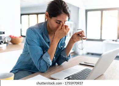 Aufnahmen von gestressten Geschäftsfrau, die von zu Hause aus auf Laptop arbeiten, sehen besorgt, müde und überfordert aus. 