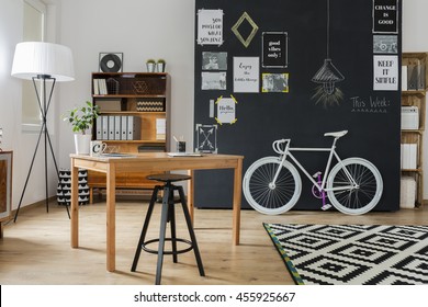 Shot of a stylish studio interior with a minimalistic workspace and a big blackboard - Powered by Shutterstock