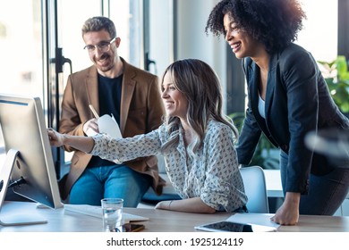 Shot of successful business multiage team standing around computer for presentation of work in the coworking space. - Powered by Shutterstock