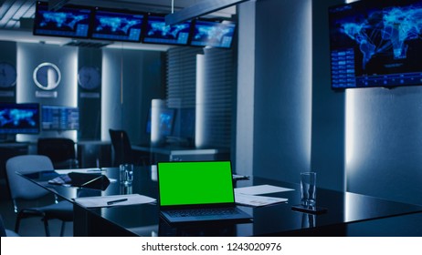 Shot Of The System Control Monitoring Room. Empty Government Emergency Operations Center. On The Table Laptop Showing Green Mock-up Screen.