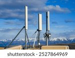 A shot of telecommunication towers standing against the breathtaking backdrop of snow-capped mountains. The towers symbolize modern connectivity amidst the untouched beauty of New Zealand