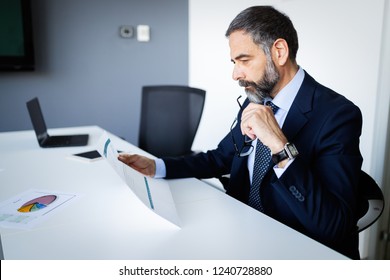 Shot of thinking financial advisor businessman working in office. - Shutterstock ID 1240728880