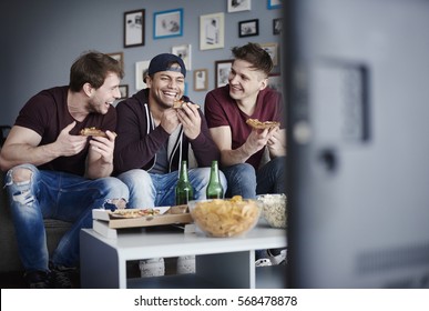 Shot Of Three Guys Having Junk Food 