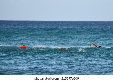 shot of three lifeguards swimming in ocean trying to save someone