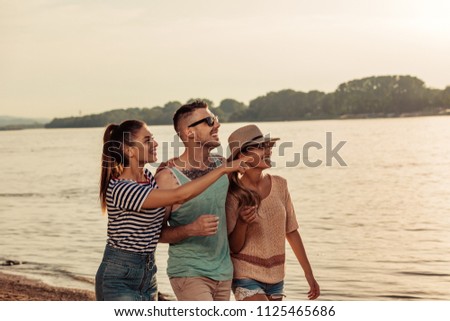 Shot of three young friends having fun by the river
