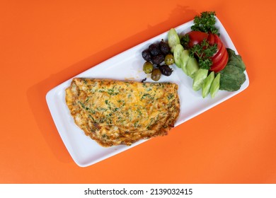 Shot From A Top Angle With Selective Focus On An Orange Background In An Isolated Setting; Image Of Chopped Cucumber And Tomato Slices, Olives And Veggie Omelet.