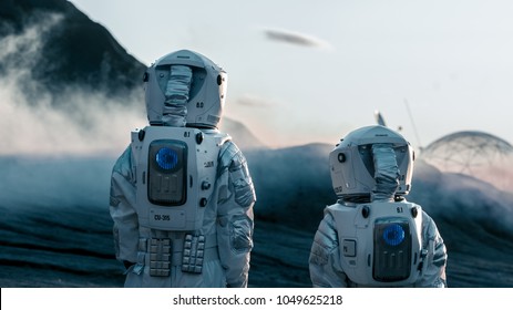 Shot of Two Astronauts Confidently Walking on Alien Rocky Planet that is Covered with Gas and Smoke. Humans Overcoming Difficulties. Scientific Progress. - Powered by Shutterstock