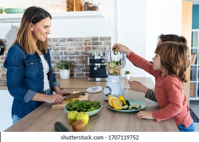 Shot of two boys helping his mother to prepare a detox juice with blender in the kitchen at home. - Powered by Shutterstock