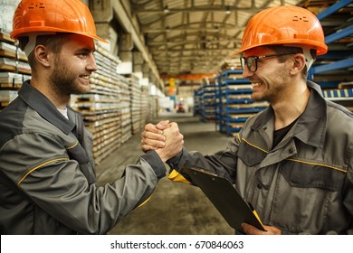 Shot Of Two Cheerful Male Workers In Hardhat And Protective Uniform Shaking Hands While Working At The Hardware Factory Manufacturing Production Plant Positivity Success Teamwork Collaboration