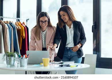 Shot of two fashion designers working with laptop and deciding details of clothes new collection in the sewing workshop. - Powered by Shutterstock