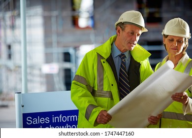 Shot of a two mature architects looking over the blueprints  of a building site