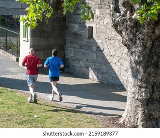 A Shot Of Two Men Jogging In Park In Dublin, Ireland