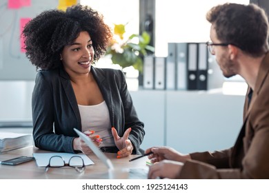 Shot of two smart multiethnic business people working together with laptop while talking about job news in the office. - Shutterstock ID 1925124143