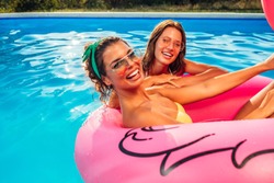 Shot Of Two Smiling Young Women Having Fun At The Swimming Pool