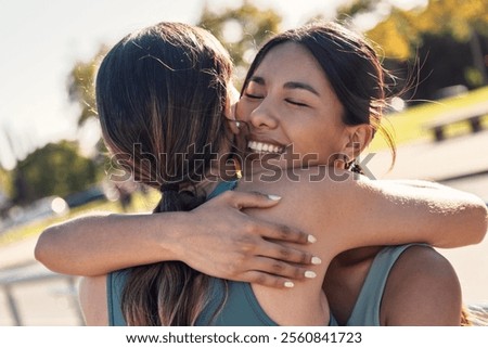 Shot of two sporty friends celebrating with a hug after going for a run around the city