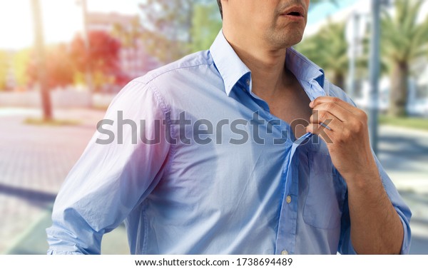 Shot of an unrecognizable man\
undressing because of the heat and sweat on a hot summer\
day