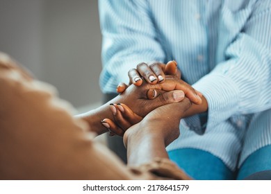 Shot of an unrecognizable senior man holding hands with his daughter while sitting on a couch at home. Her support means everything to me. Young woman holding older man hands - Powered by Shutterstock
