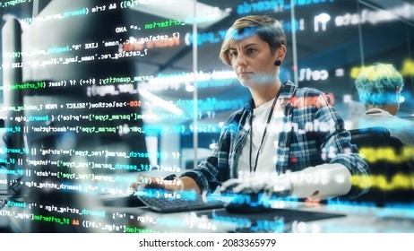 Shot With Visualisation Of Running Computer Code On Foreground. Portrait Of Motivated Woman With Disability Using Prosthetic Arm To Work On Computer In Body Positive Office. Myoelectric Bionic Hand