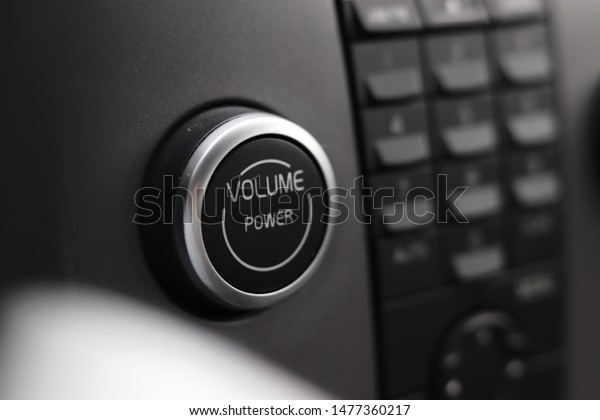 A shot of a
volume power push button on a
car.