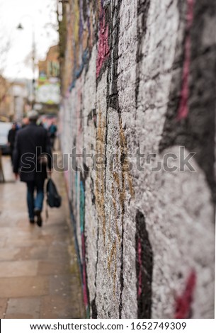 A shot of a wall with graffiti looking down a street in Shoreditch in East London