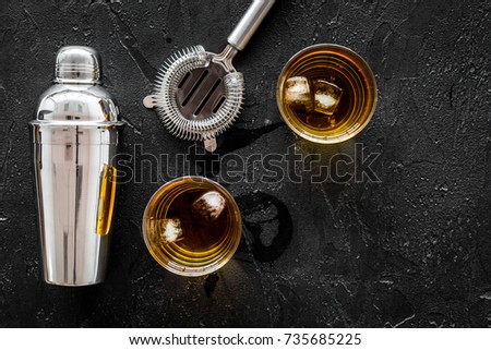 shot of whiskey with ice and barmen equipment black table background top view space for text