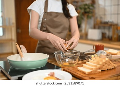 Shot of woman cracking an egg into a glass bowl - Powered by Shutterstock