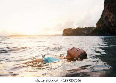 Shot of a woman floating on her back in the ocean - Powered by Shutterstock