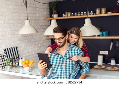 Shot Of A Women Holding A Credit Card And Purchasing Online.