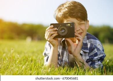 Shot Of A Young Boy Taking A Picture With A Vintage Instant Camera While Lying On The Grass In The Park On A Sunny Summer Day Copyspace Sunlight Photography Hobby Children Childhood Lifestyle Leisure